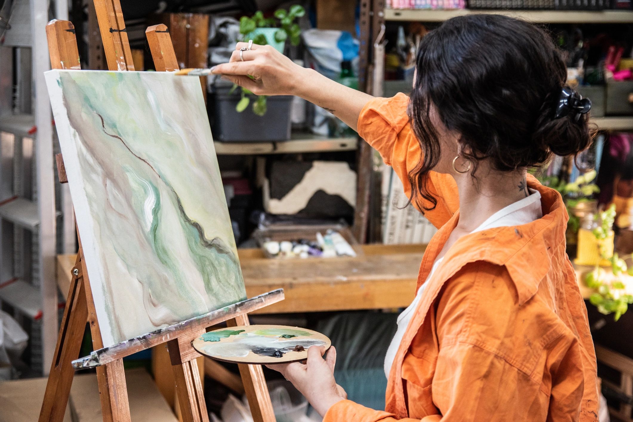 Artist painting on canvas in a bright studio